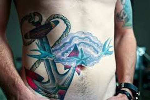 Tatouage d'une ancre sur le ventre d'un homme - photo