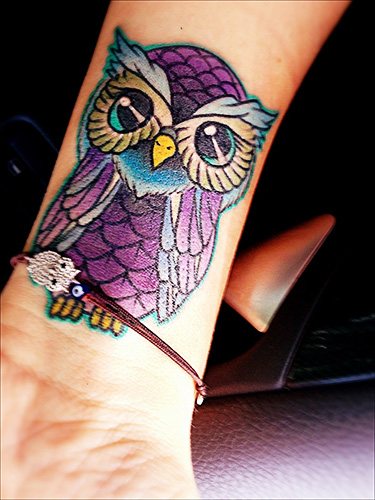 Tatouage d'une chouette sur le bras pour les filles. Photo, signification, croquis