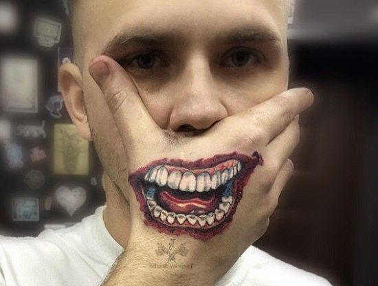 Tatouage du sourire du Joker sur son bras. Croquis, photo