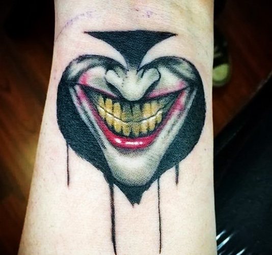 Tatouer le sourire du Joker sur son bras. Croquis, photo