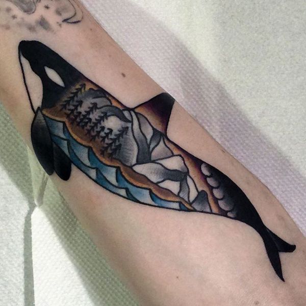 Tatouage avec une photo d'un dauphin et la nature en arrière-plan