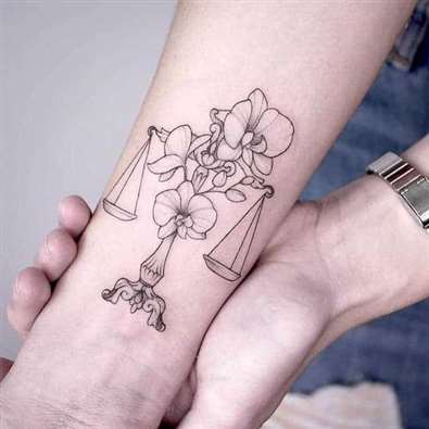 Tatouage de la Balance en combinaison avec des fleurs