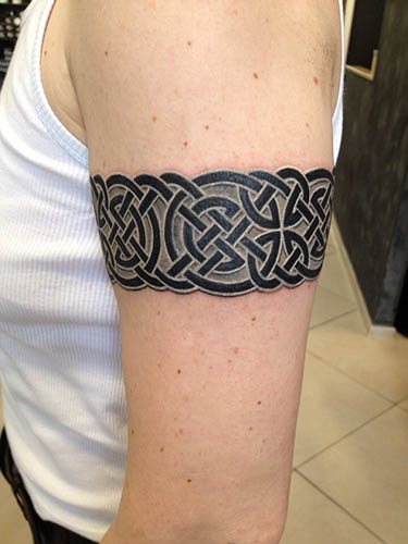 Tatouage autour du biceps homme, femme. Photo : dans le style slave, le motif scythe, les nœuds celtiques