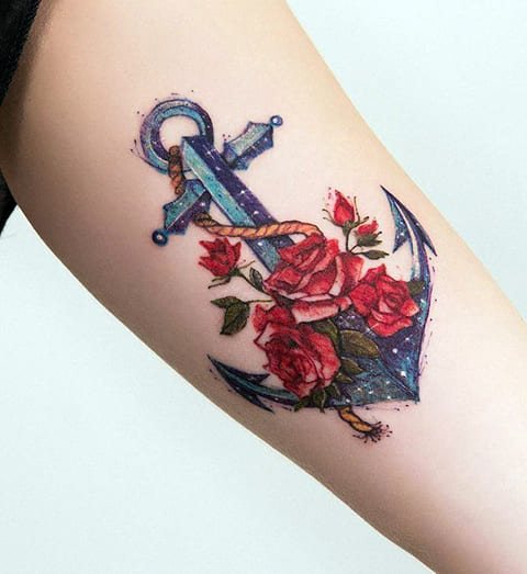 Tatouage d'une ancre avec des roses sur un poignet de fille