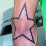 Tatouage d'une étoile sur le coude