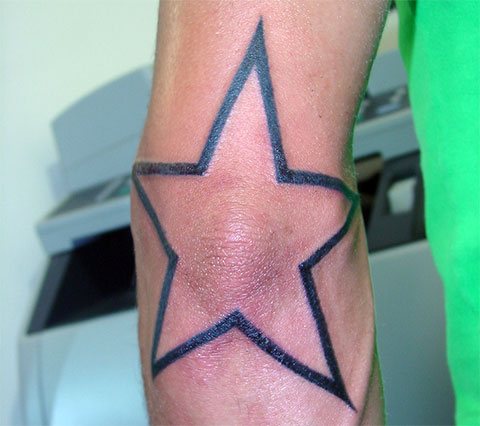 Tatouage d'une étoile sur le coude