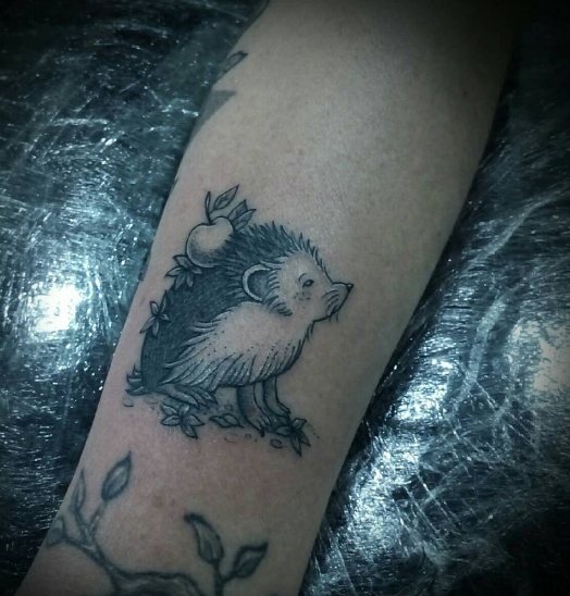 Hérisson de pomme tatoué sur l'avant-bras