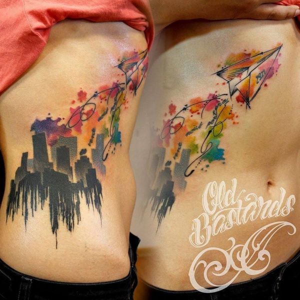 Tatouage en aquarelle d'une ville avec un avion