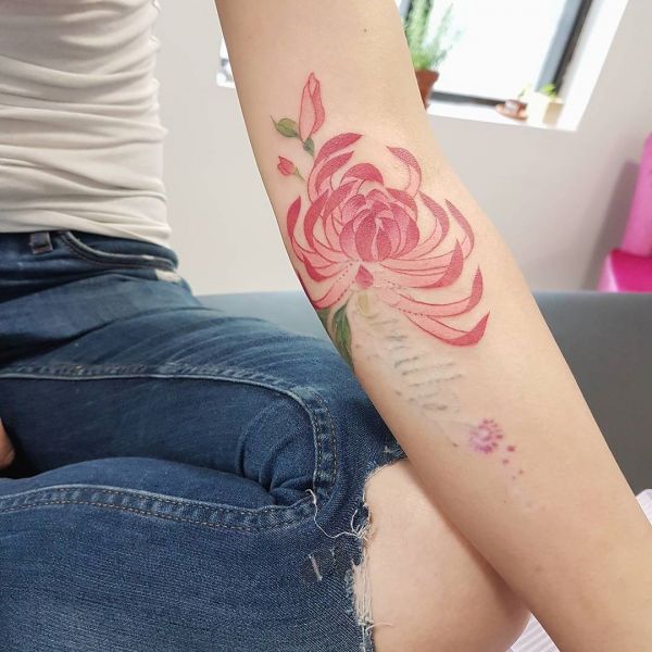Tatouage de chrysanthème rouge sur le bras d'une fille