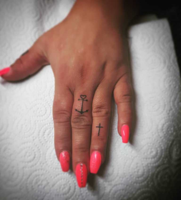 Tatouage d'une croix sur un doigt