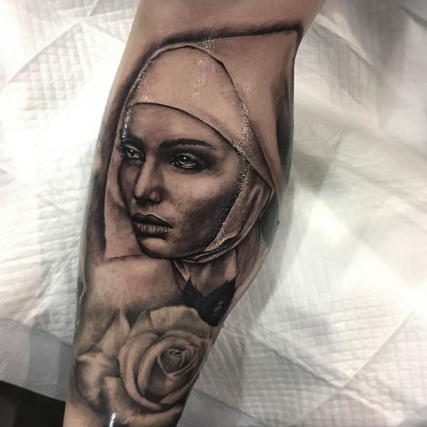 Tatouage d'une religieuse avec une rose sur son bras