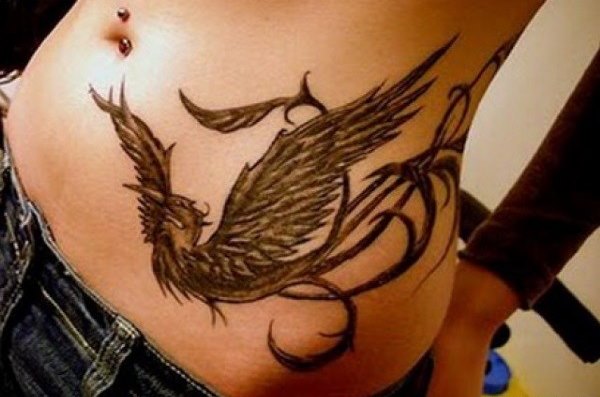 Un tatouage sur le ventre pour les filles après l'accouchement pour cacher les vergetures. Avantages et inconvénients
