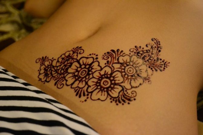 Tatouage sur l'abdomen pour les jeunes filles en post-partum pour cacher les vergetures. Avantages et inconvénients.