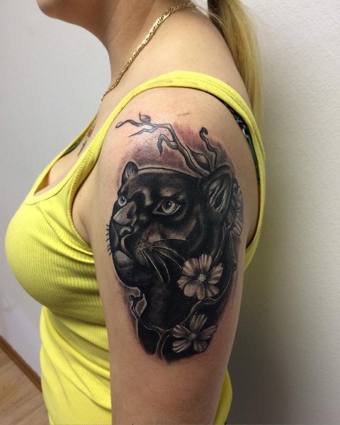 Tatouage de panthère avec des fleurs sur l'épaule d'une femme