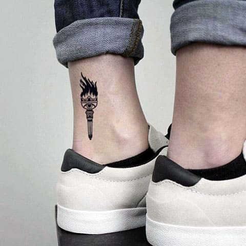 Tatouage d'une petite torche sur sa jambe