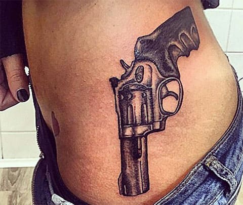 Tatouage d'un pistolet sur le côté d'une fille