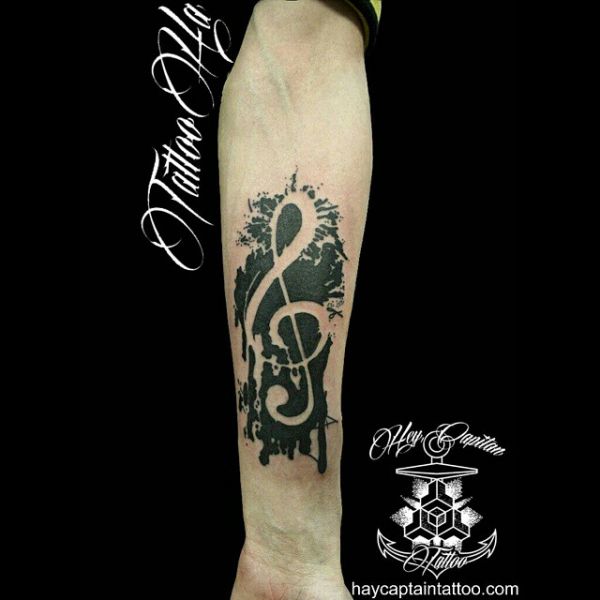 Tatouez une clé de sol sous forme de notes noires sur votre avant-bras.