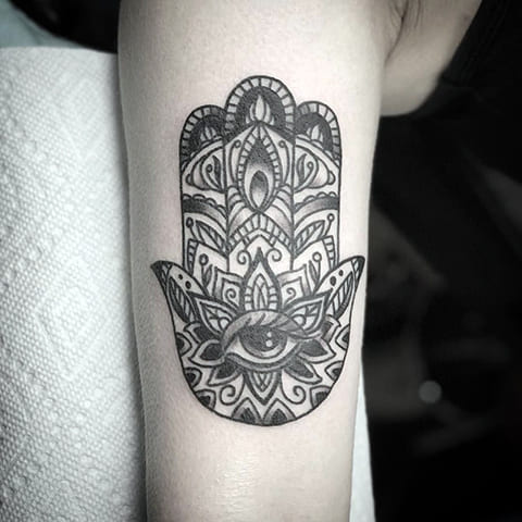 Tatouage sur le bras d'une fille - bras de Fatima avec un œil