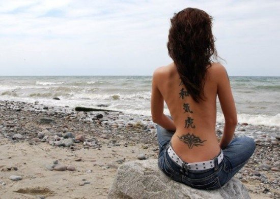 Tatouages sur la colonne vertébrale (dos) des filles : hiéroglyphes, inscriptions avec traduction, fleurs, point, runes, planètes, lignes. De beaux dessins
