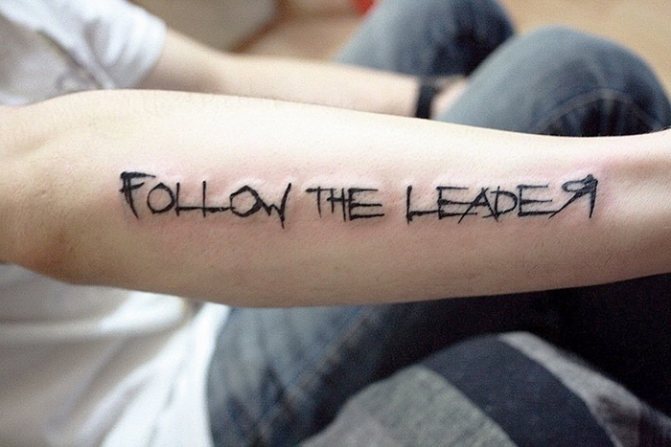Tatouages sur le bras avec des traductions en latin. Image et signification