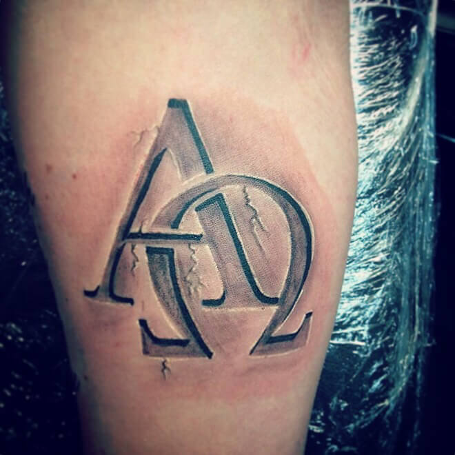 Tatouage de l'Alpha et de l'Omega sur le pied d'un homme