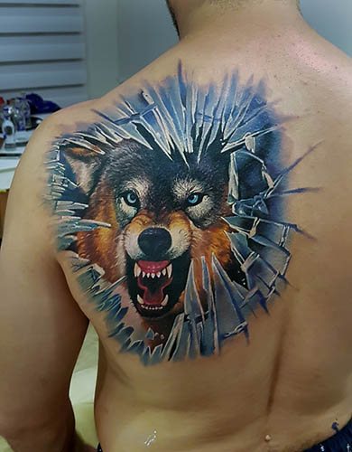 Un tatouage de sourire de loup. Photo, signification sur l'épaule, l'avant-bras, le dos, le bras