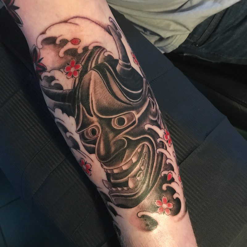Tatouage de vagues et de démons sur l'avant-bras