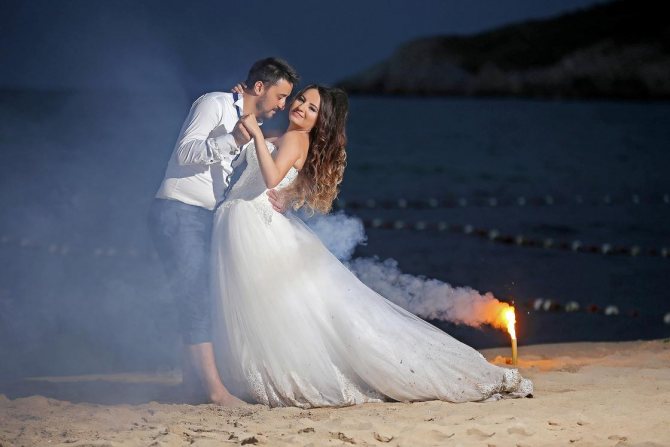 La mariée et le marié dansent sur la plage la nuit.