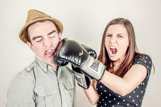 Une femme frappe un homme avec sa main dans un gant de boxe