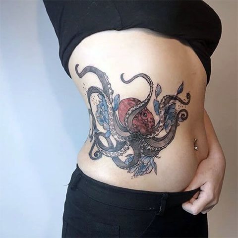 Femme tatouée d'une pieuvre sur le côté